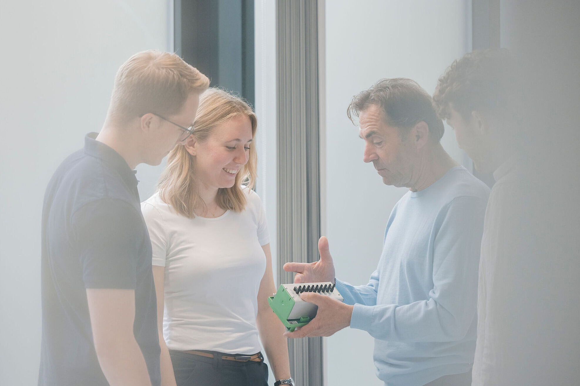Engineers discussing an electronic module during the development of a power electronics system.