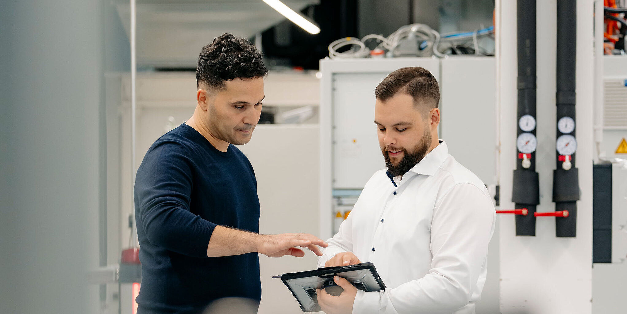 Silver Atena engineers reviewing technical data on a tablet in an engineering environment.
