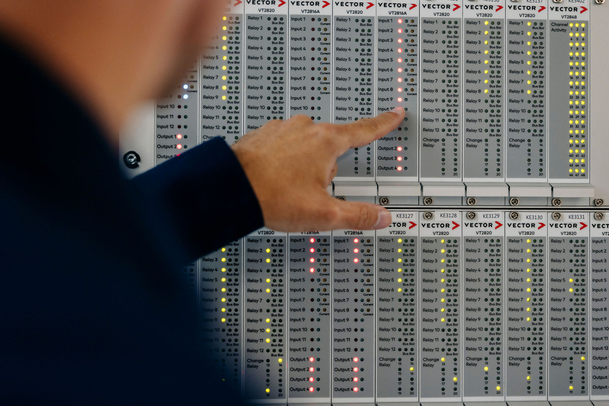 Close-up of a modular Vector test system with status indicators for relays, inputs, and outputs.
