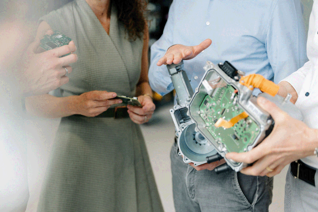 Silver Atena employees discussing printed circuit boards (PCBs) and open housing assemblies during product development.
