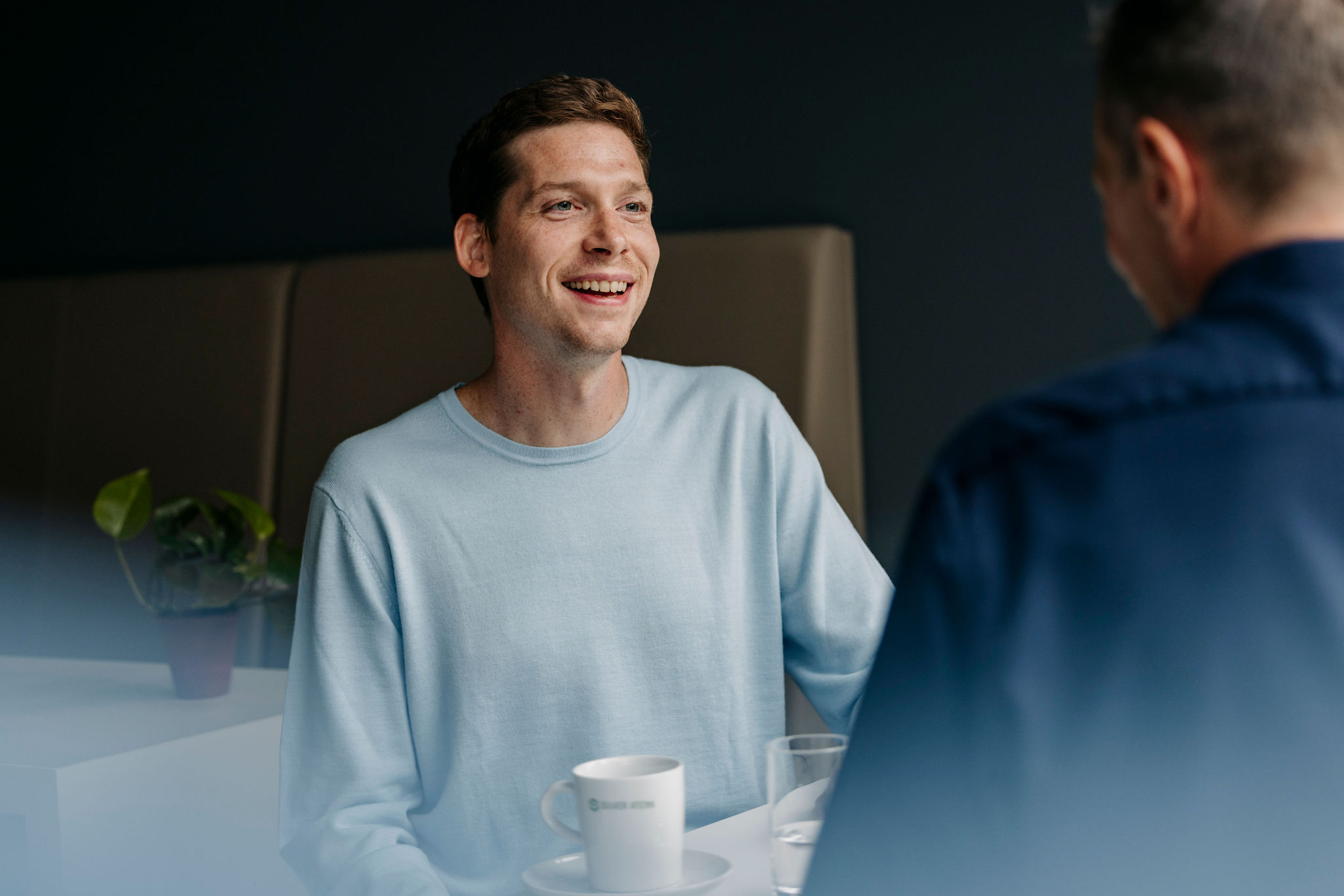Two Silver Atena employees having a relaxed conversation over coffee in the office.
