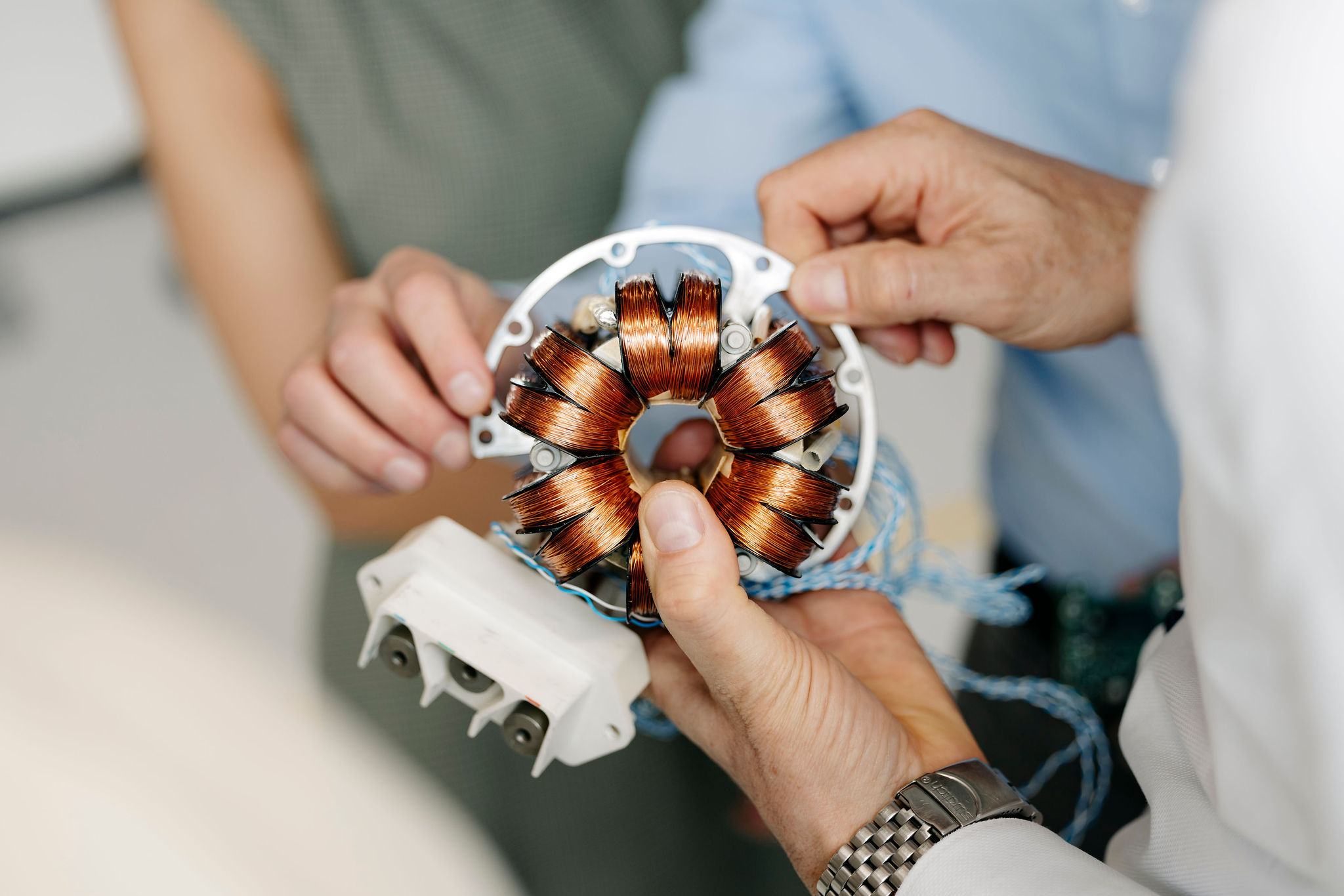 Close-up of an electric motor stator with circularly arranged copper windings during a joint technical inspection.