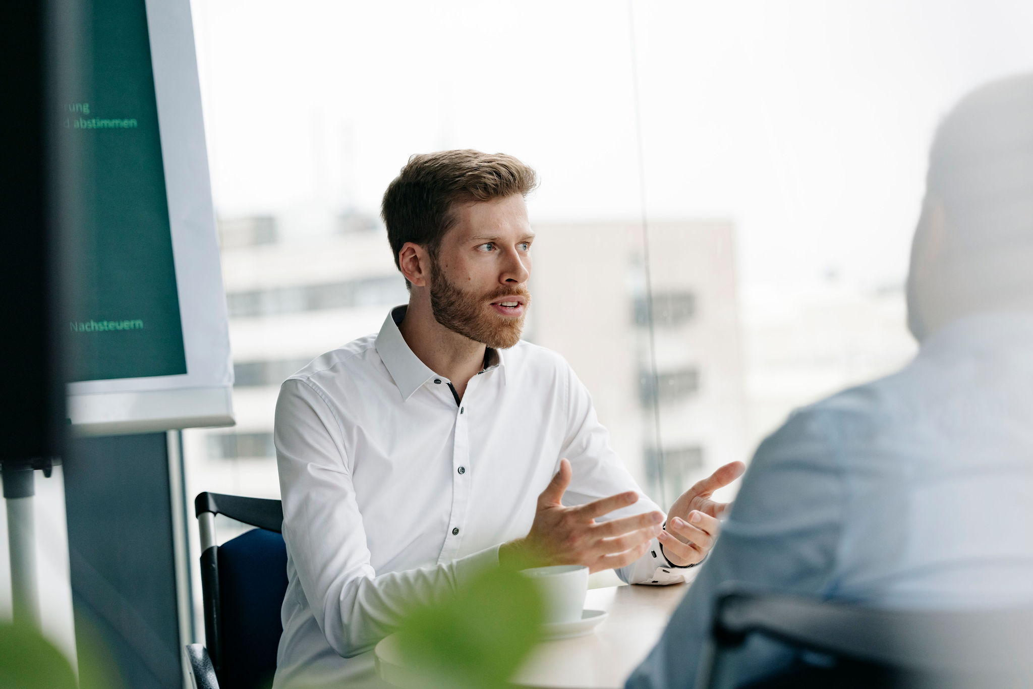 Silver Atena employee explaining technical requirements during a meeting with a colleague.