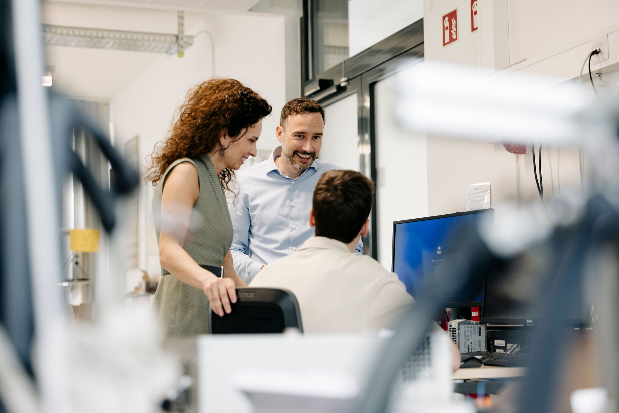 Three Silver Atena employees discussing test results together at a laboratory workstation.