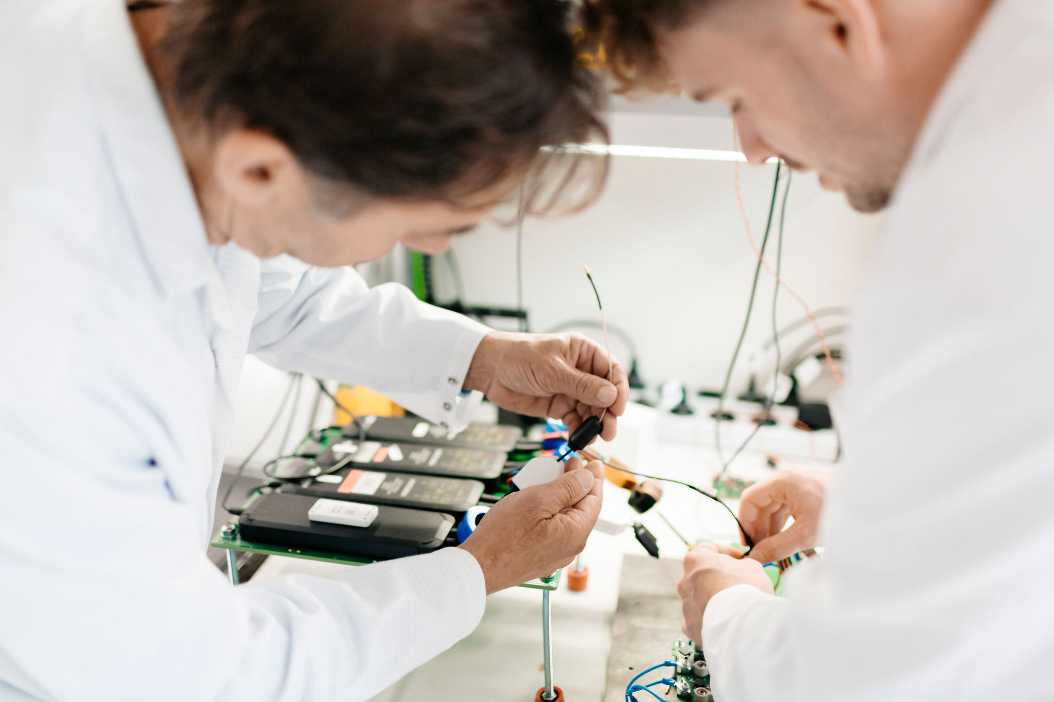Silver Atena engineers connecting electronic components during a laboratory system test.