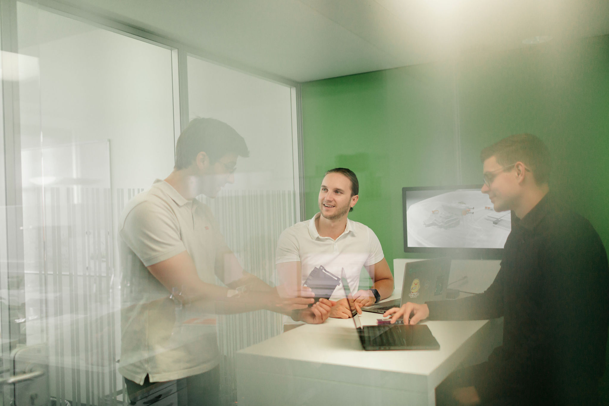 Silver Atena engineers discussing a technical component during a development meeting.