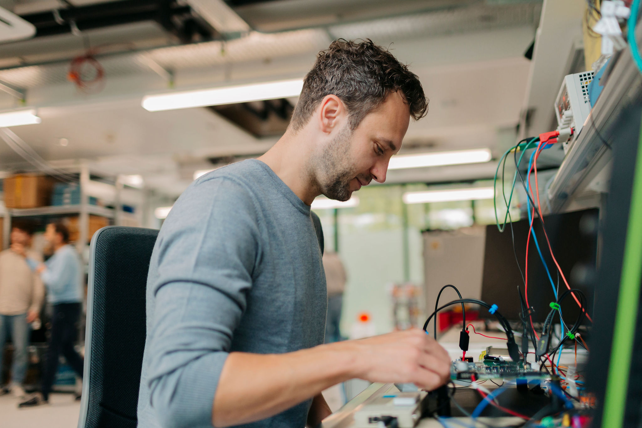 Person working on an electronic unit at a development workstation.